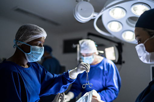 Surgeon passing a scissor to assistant Surgeon passing a scissor to assistant