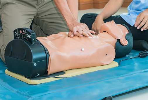 RefresherCourses2 CPR aid dummy medical training with hand press Heart on doll emergency refresher training Concept closed-up.